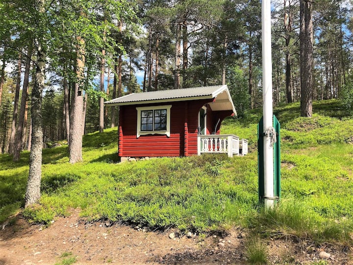 A narrow double bed and table and chair a cozy room