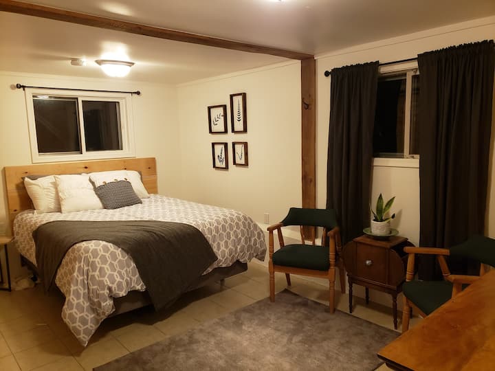The master bedroom has a queen bed and little seating area for privacy.