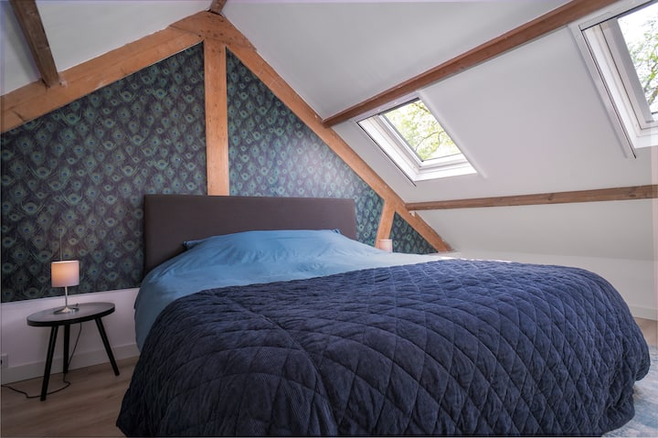 Open slaapkamer op de vide, met zicht op de woonkamer beneden