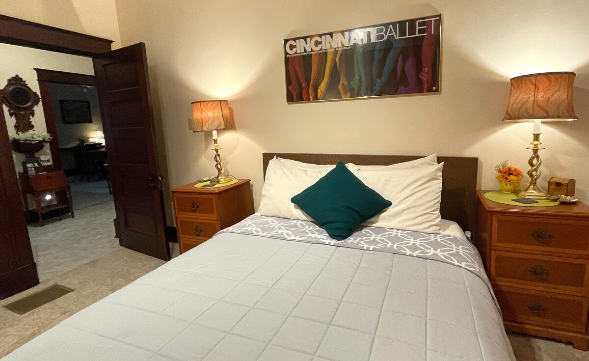 ห้องนอน 1
เตียงควีนไซส์พร้อมโต๊ะข้างเตียงโคมไฟและที่ชาร์จ USB บนเตียงแต่ละข้าง หมอน 4 ใบบนเตียงโต๊ะเครื่องแป้งเก้าอี้นั่งตู้เสื้อผ้าอยู่ด้านซ้ายถัดจากประตูทางเข้า