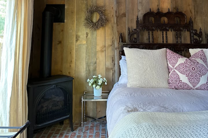 First floor bedroom of Guest House. King bed, gas pot belly stove, and AC
