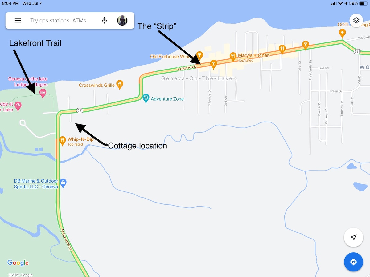 A map outlines the location of the cottage along the Lakefront Trail. Arrow indicators point toward key landmarks, including The Strip and surrounding establishments. The layout emphasizes accessibility to nearby attractions, creating a clear visual reference for navigation.