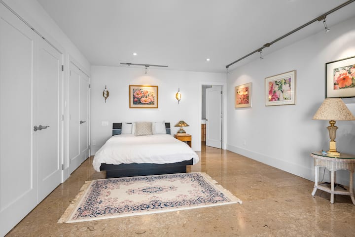 Main floor queen bed in bedroom with two closets and en-suite bathroom