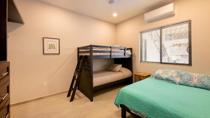 Segundo dormitorio con una cama individual y una litera y un gran espacio de armario.