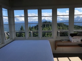 The queen mattress has a waterproof cover pad, but you cover it with your own sheets/blankets/sleeping bags as you prefer.  (Those are Jumbo and Whitehorse mountains in the photo)