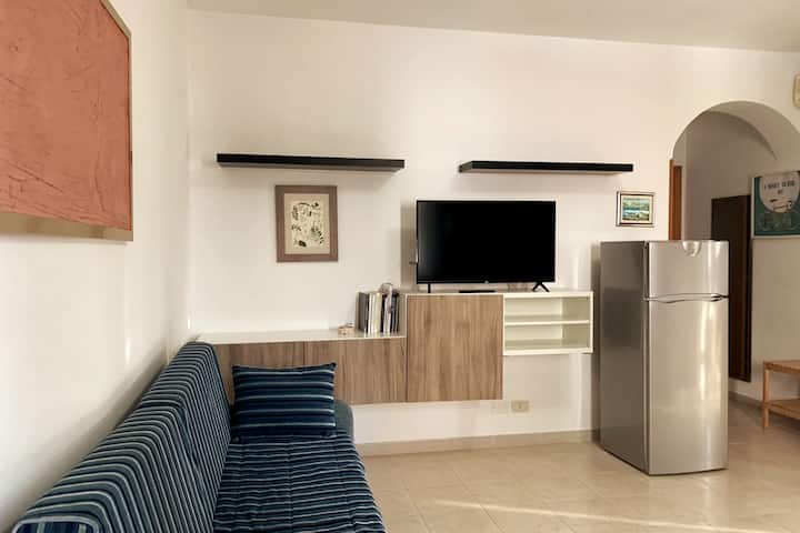 The air conditioner is located in the hallway that leads to the bedroom and bathroom