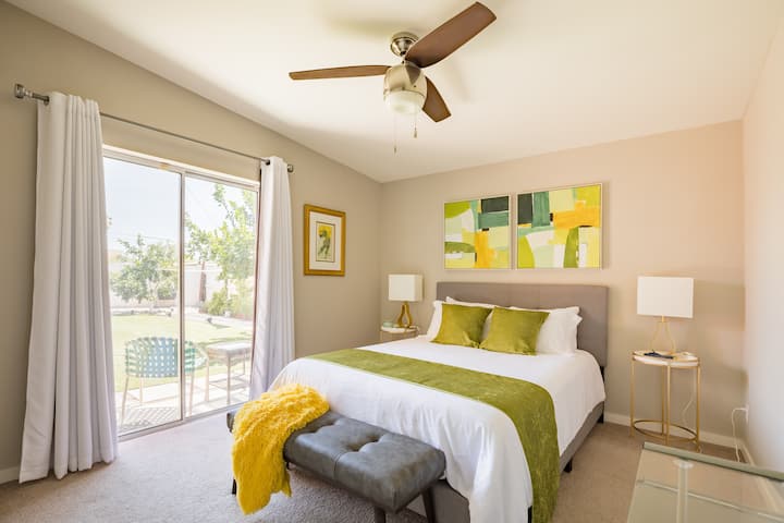 Жълта спалня за гости с двойно легло и мобилна работна станция