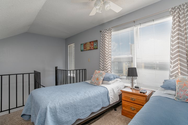 ห้องใต้หลังคาชั้น 3 พร้อมเตียงแฝด 2 หลังและวิวบันไดเวียนที่นำไปสู่