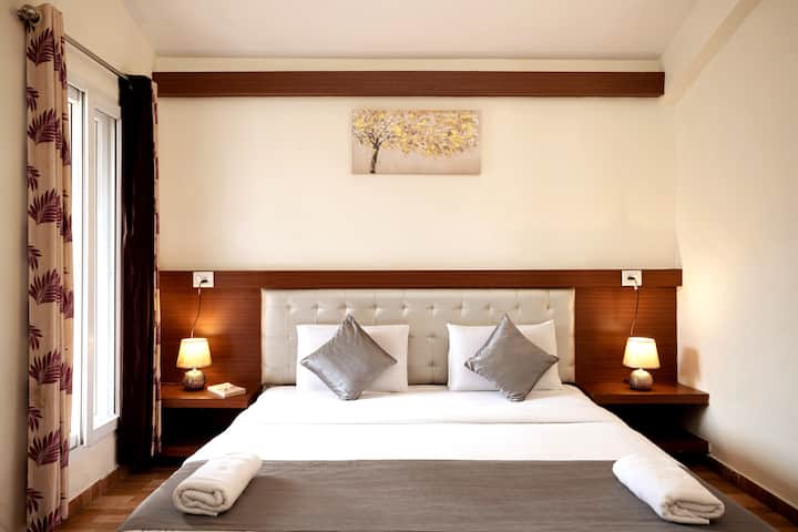 Modern King-Size Bed | Wingback Tufted Headboard | Bedside Tables | Wardrobe | Split Air Conditioning | Attached Balcony