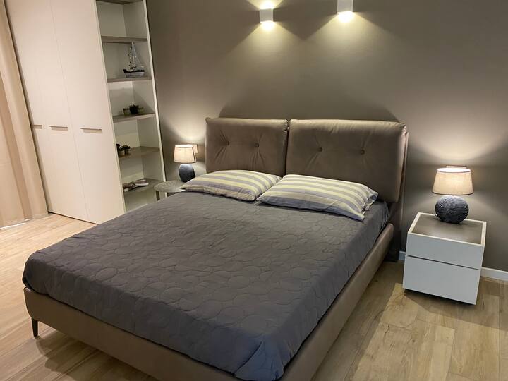 חדר שינה גדול עם מיטה זוגית
שידות ליד המיטה ושני ארונות נפרדים גדולים עם מראה