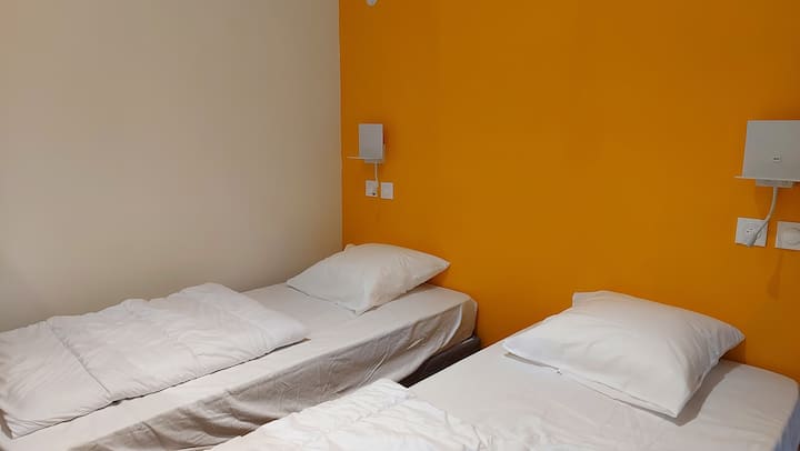 Habitación HORUS con 4 camas individuales y un baño privado.
