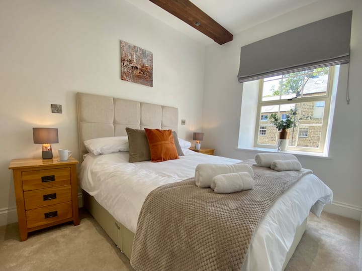 La chambre du premier étage, une merveilleuse retraite qui dispose d'une décoration simple mais sophistiquée, d'un rangement et d'un lit king size délicieusement confortable habillé de linge blanc impeccable, de coussins dispersés et d'un jet confortable.