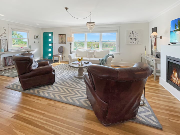 Espacio habitable cálido y acogedor con sofá cama tamaño queen Pottery Barn y sillas reclinables del club de cuero Restoration Hardware