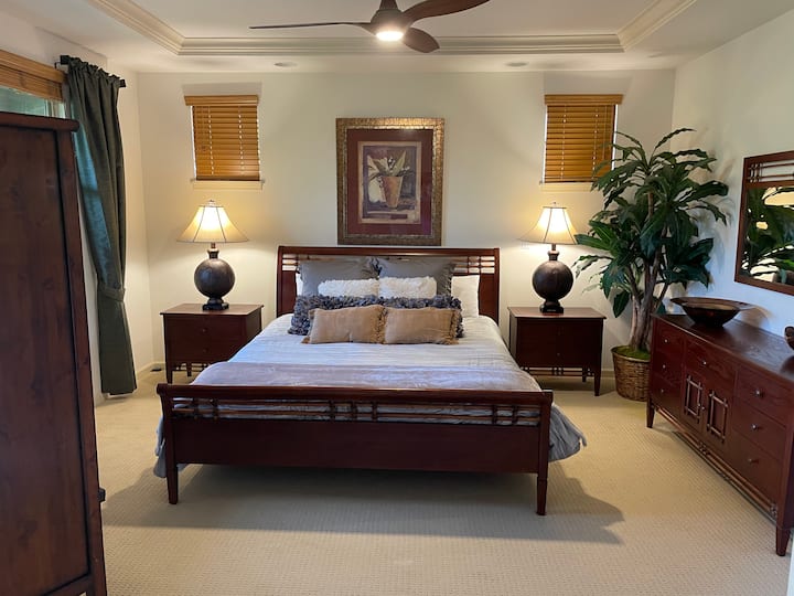 Private and Spacious Master Bedroom with a king size bed with a Tempurpedic mattress, ceiling fan and 4k Smartcast Vizio TV and DVD player tucked away in the armoire. Guest bedroom on opposite end of hallway.