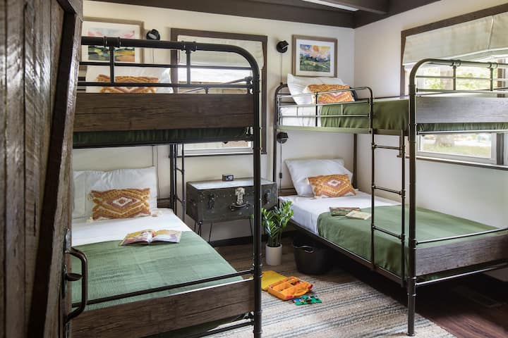 The second bedroom is perfect for kids. Each comfy bunk has a reading light for falling asleep while reading. The room is stocked with toys including legos, marble run, books for younger kids, a baby doll, and a toy car set with tracks.