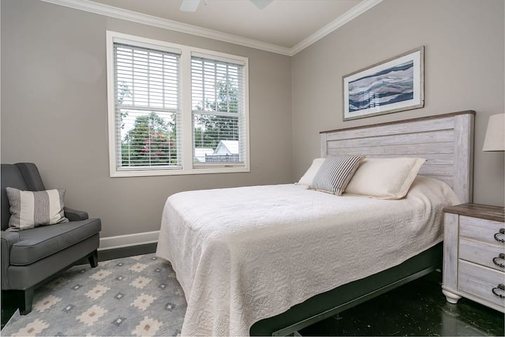 חדר שינה תחתון עם שידה וטלוויזיה. 