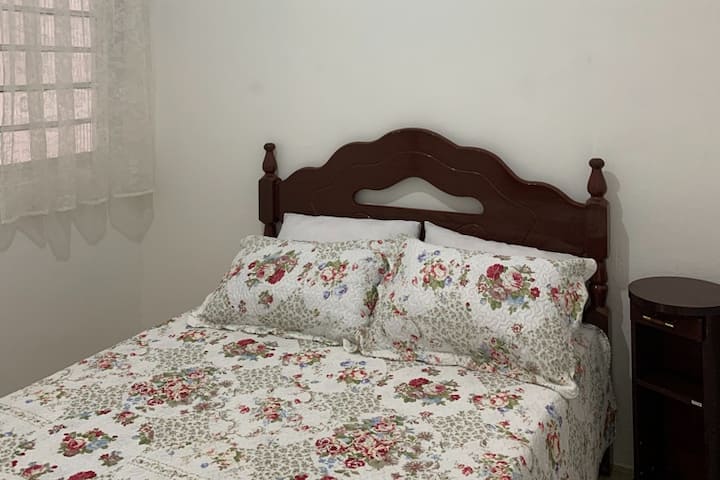 Segundo dormitorio: 1 cama doble, valet de pie, espejo en la pared, estante y criada.