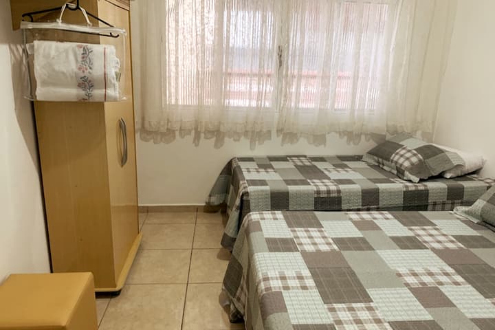 Tercer dormitorio: 1 cama doble, 2 camas individuales, armario de 2 puertas, puf, perchero y espejo en la pared.