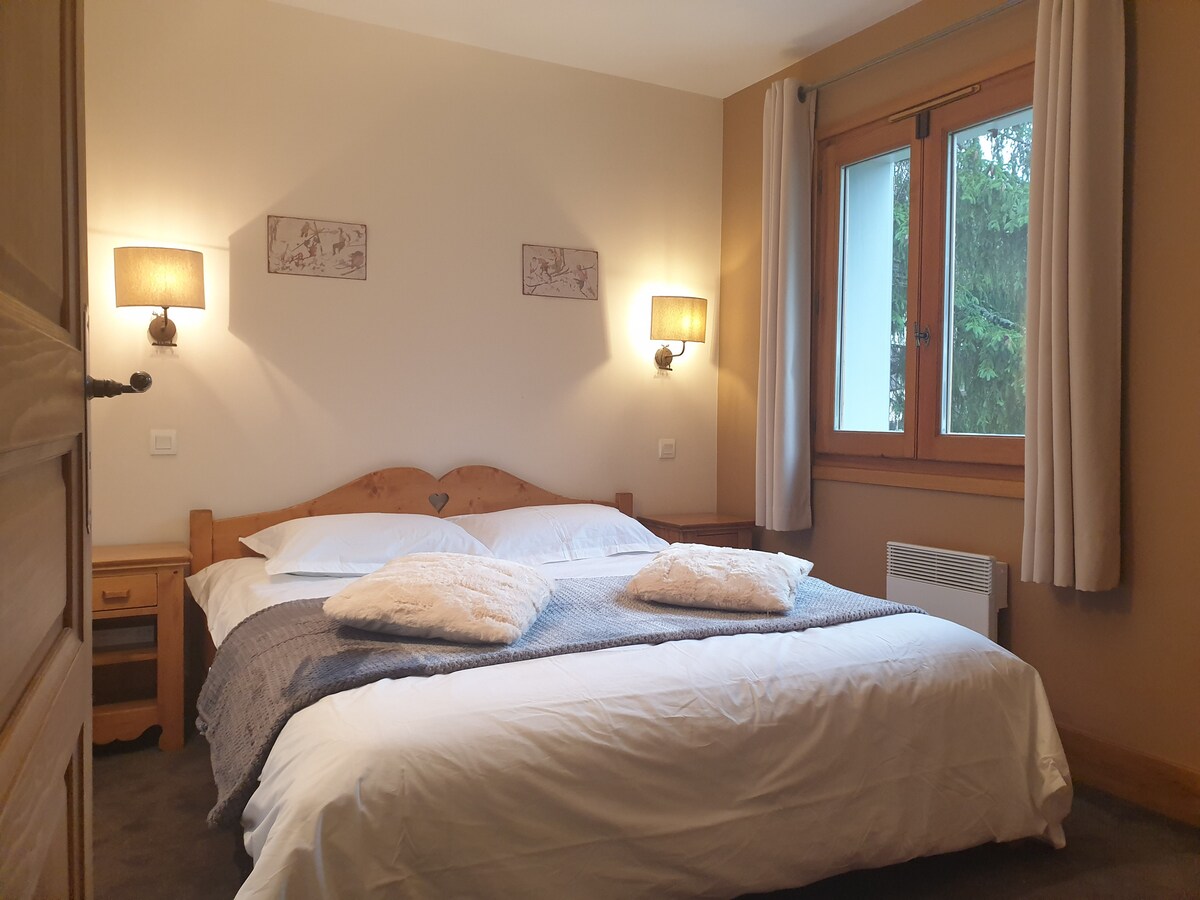 Slaapkamer één, met een tweepersoonsbed, twee nachtkastjes en opbergkast. Een tv maakt deze prachtige kamer compleet met uitzicht op de Zwitserse Alpen.