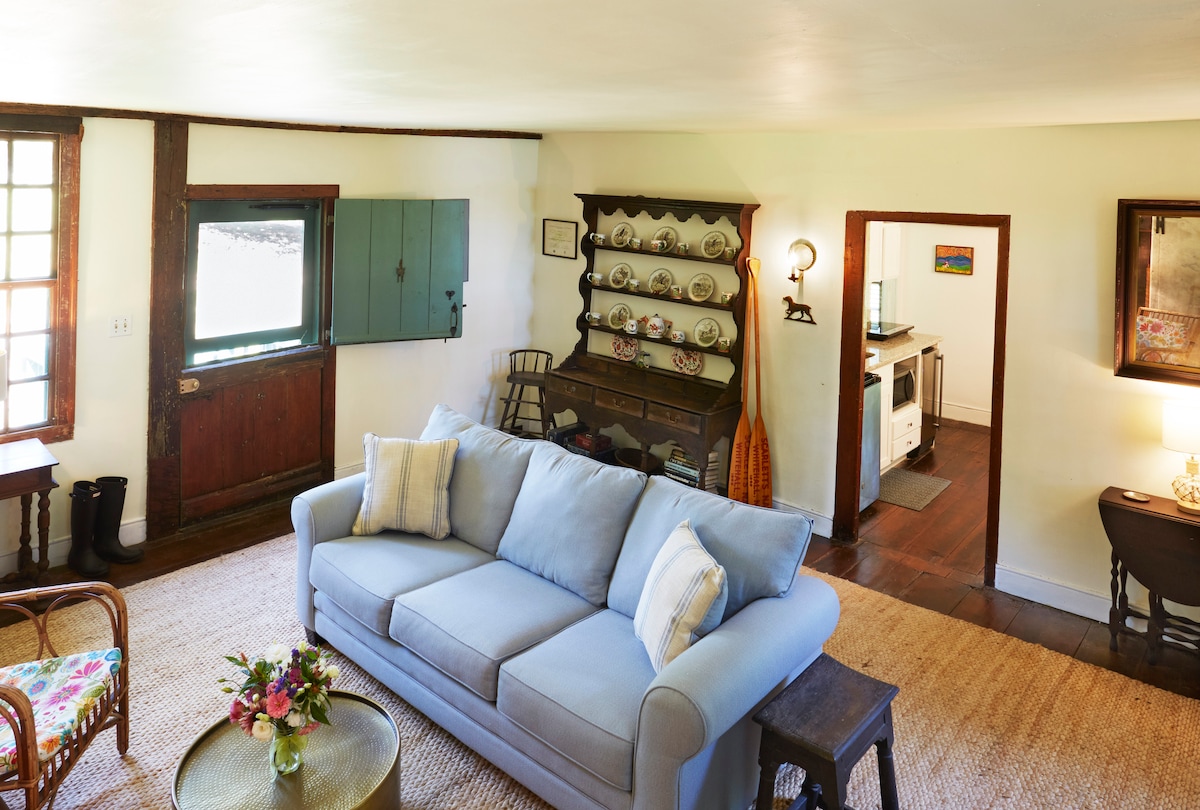 Relax in the charming living room with a cozy combination of antiques and modern-day comforts.