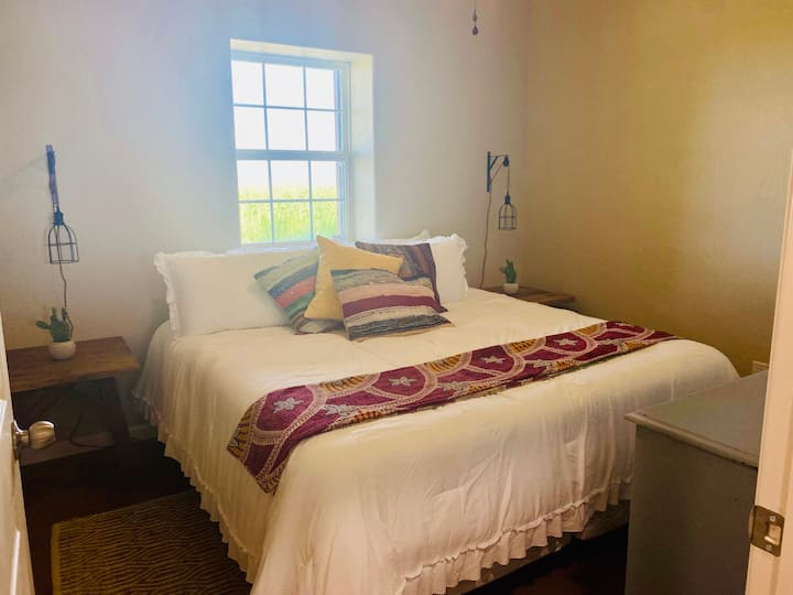Dormitorio tamaño king con vista a los pastos traseros.