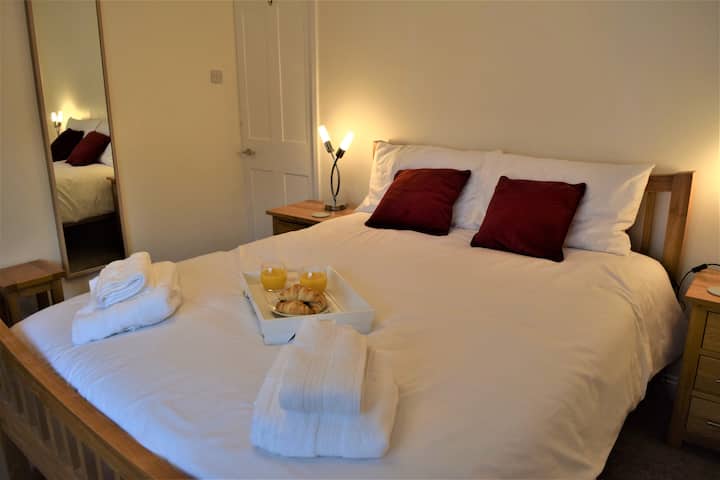 宽敞朝南的主卧室，配备加大双人床、梳妆台和大衣柜。