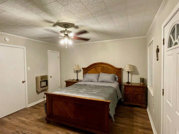 Large spacious bedroom hosting a queen size bed,  walk in closet, and a Dresser for storage. A luggage rack, and air mattress are also available. 