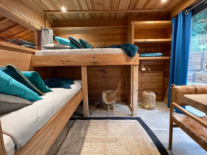 La chambre océan 2 lits pour une personne ..Une grande chambre cosy avec petit bureau et télévision une grande B vitrée donne accès sur la terrasse côté forêt