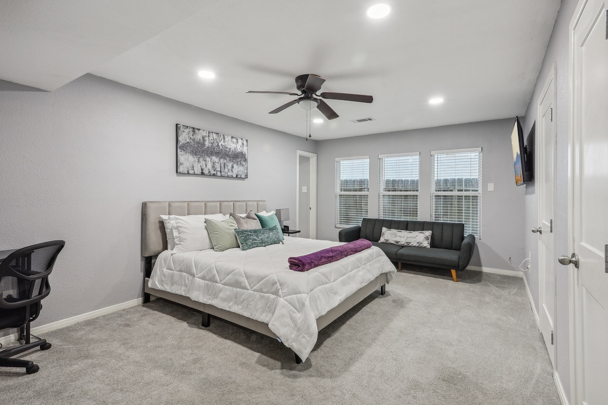 Relájate con estilo en el dormitorio principal del piso 1, con una lujosa cama tamaño king, un cómodo sofá, un armario con vestidor, una estación de trabajo y un televisor Roku de 55 pulgadas. Disfruta de una excelente noche de sueño en el colchón Zinus Green Tea Memory Foam. Netflix, HBO Max y Disney+