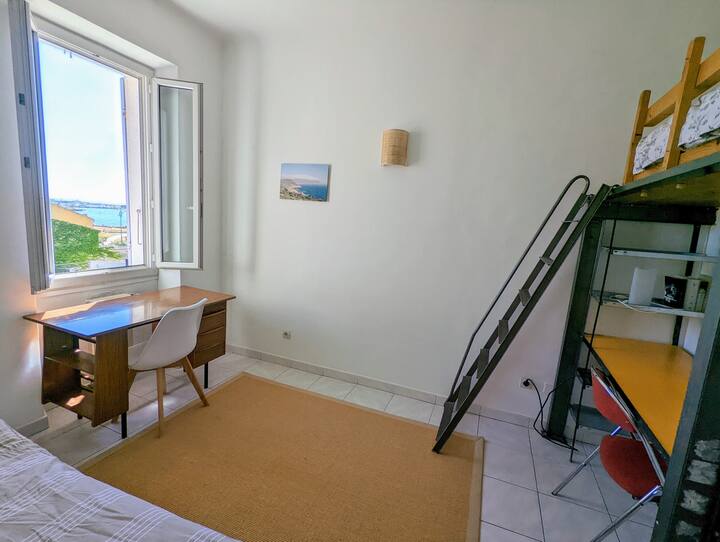 חדר שינה עם 2 מיטות יחיד (אחת בקומת הביניים) ו -2 שולחנות. נוף להרים ולים.