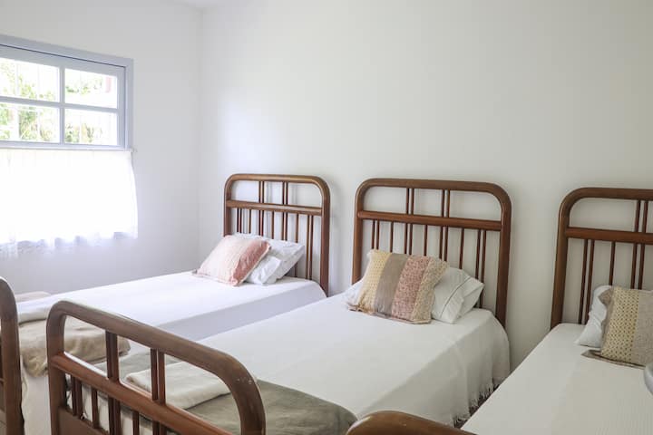 Casa Jasmim -客房，配有3张单人床，窗户可通往森林中的茉莉花