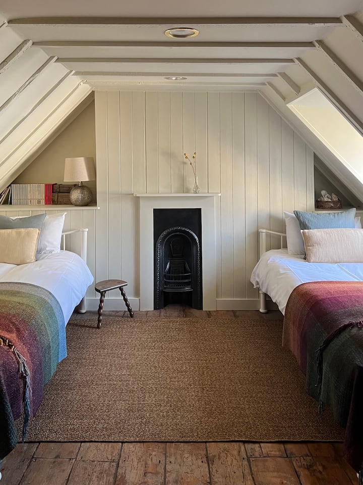 The loft bedroom has twin beds, small desk and a sea view (only just!). You'll find a stair gate, Baby Bjorn travel cot and hanging space in the inbuilt cupboard.