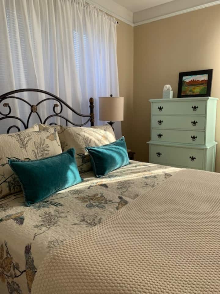 Das Queensize-Bett hat Memory Foamam Topper, frische Baumwollbettwäsche und Baumwollaufstrich. Reine Vorhänge und Jalousien ermöglichen es dir, das Zimmer zum Schlafen oder ein Mittagsschläfchen zu verdunkeln. Deckenventilator über dem Bett.