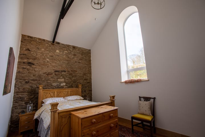 second kingsized bedroom with vaulted ceiling, arched window and ensuite bathroom