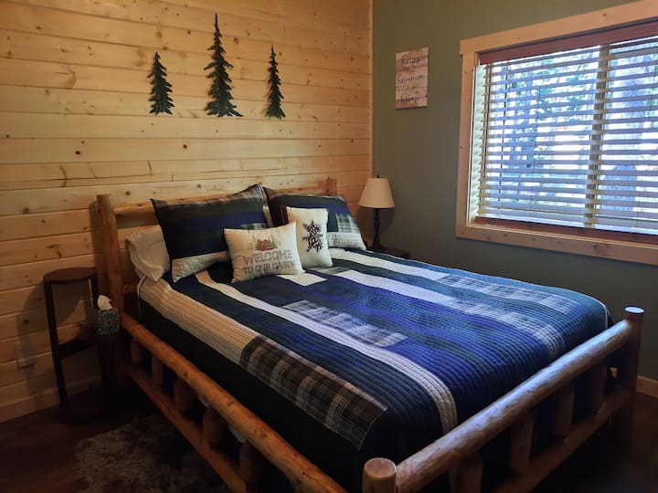 Comfortable queen size log bed, night stand with lamp and alarm clock.  USB plugs on both sides of the bed.