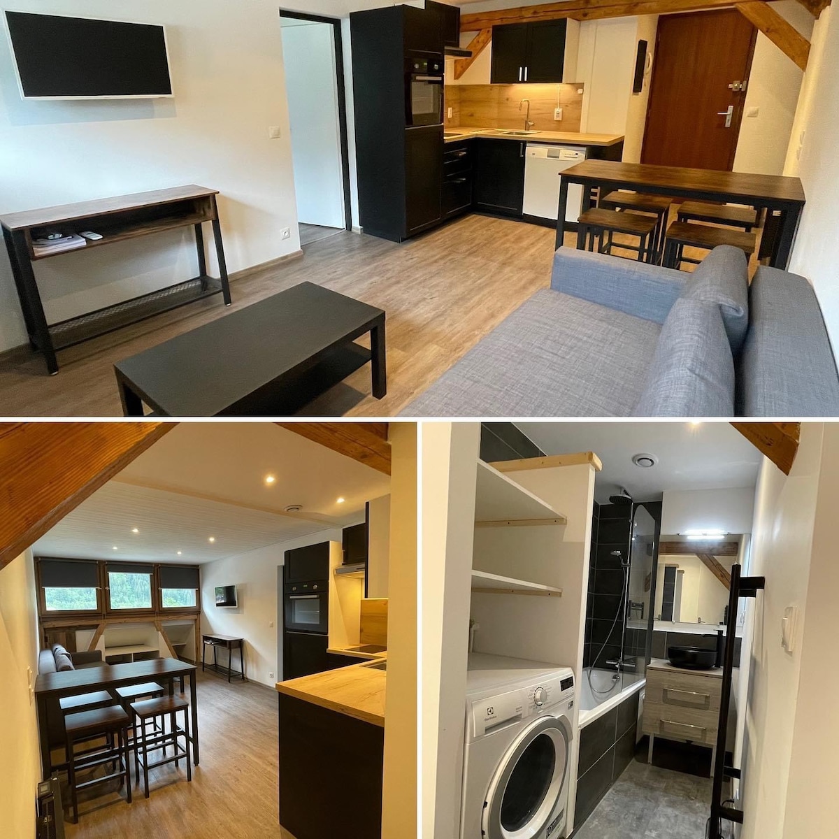 A modern living space features sleek black cabinetry and wood accents. A comfortable gray sofa invites relaxation, complemented by a adjacent dining table and minimalist decor. The kitchen area includes essential appliances and a washer, with large windows allowing natural light to enhance the ambiance.