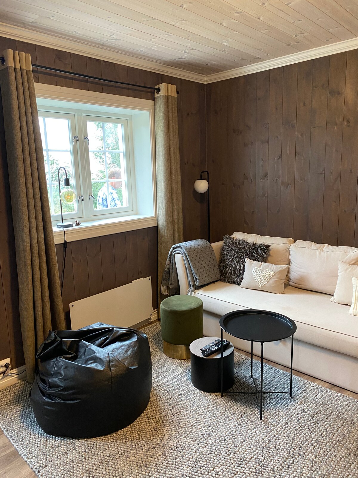 Sala de estar en el sótano con TV y salida al patio.