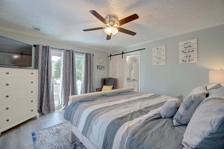Primary Bedroom: Relax in style with airy decor and comfy bedding right by your private bath!