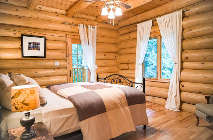 Wooden Walls and Floors: The bedroom features wooden walls and floors, creating a warm and inviting atmosphere that complements the rustic theme of the cottage.