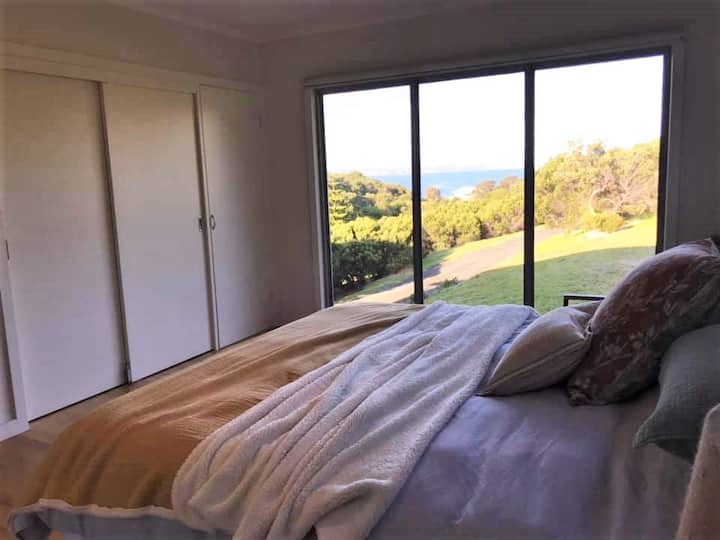 Spacious master bedroom with views of the ocean and a comfortable king size bed.