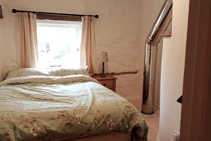 Cama matrimonial. Enchufes de Usm. Armario. Lámpara. Armario junto a la cama. La tubería de la chimenea de acero inoxidable pasa por el dormitorio. 