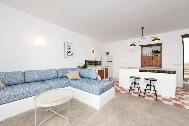 Photography of the living area and kitchen. The custom-made sofa with upholstery houses two 2-meter-long double beds by 90 centimeters wide.