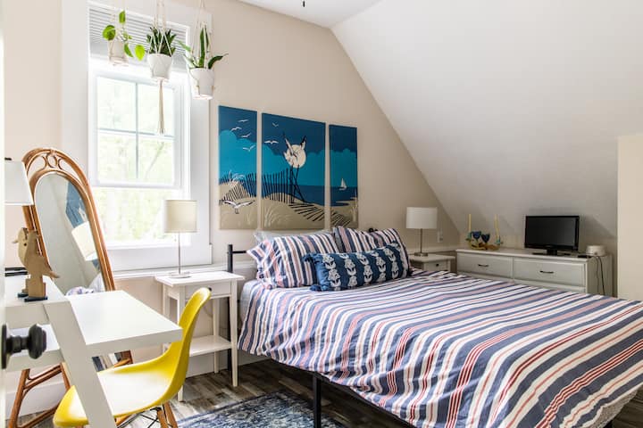 Chumba cha kulala cha baharini kina godoro zuri la povu la kumbukumbu, televisheni yenye uwezo wa Roku, kivuli cha kuzima, mashine nyeupe ya kelele, kabati, kabati na dawati dogo.