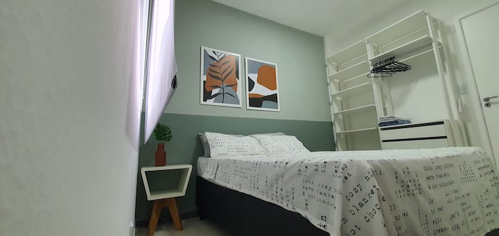Chambre avec climatisation, lit double, grand placard avec tiroirs, table de chevet, films de retraites chauds, rideau occultant et décoration confortable.