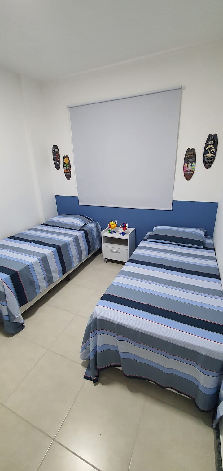 Chambre avec climatisation, 2 lits simples et un accessoire (coulissant), grand placard avec tiroirs, table de chevet, presses à chaleur, rideau occultant et décoration.