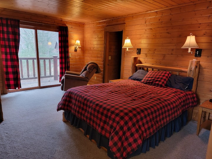 Spálňa na hlavnom poschodí s výhľadom na balkón a vchod do vlastnej kúpeľne. 