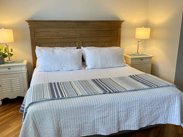 Unwind in the inviting king bedroom, with soft coastal colors and a comfortable retreat at the end of the day.