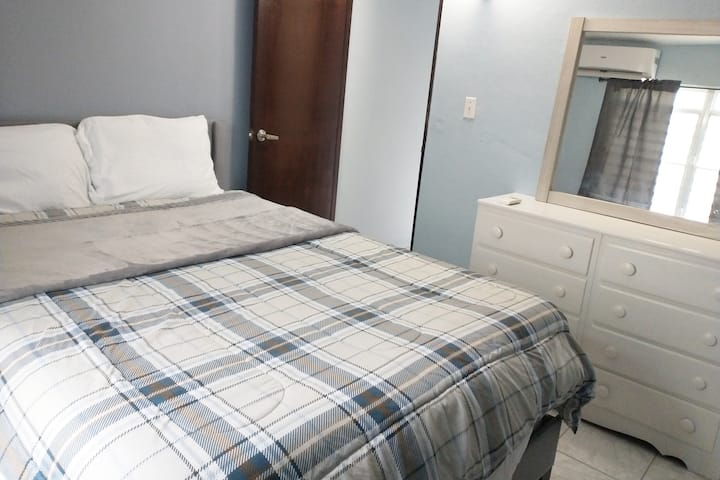 Habitación principal con cama tamaño queen y aire acondicionado.