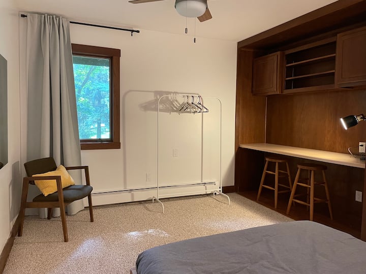 Segundo dormitorio con área de escritorio y cama tamaño queen.