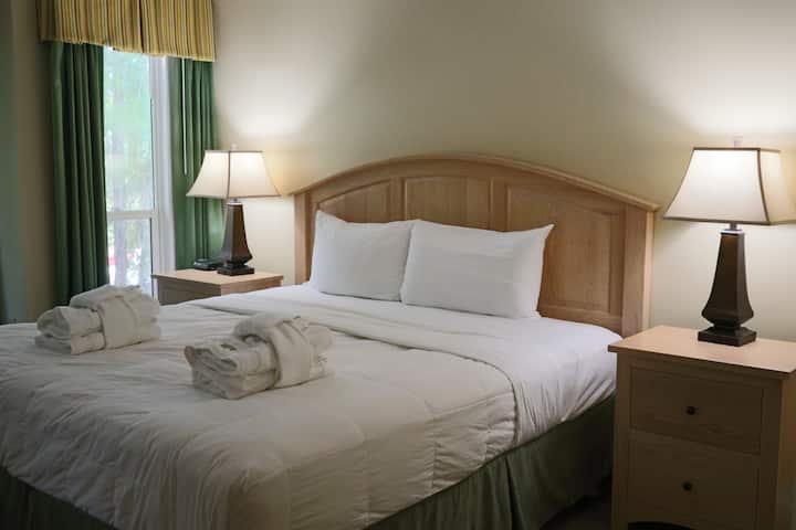 تحتوي غرفة النوم الرئيسية على سرير بمقاس كبير.